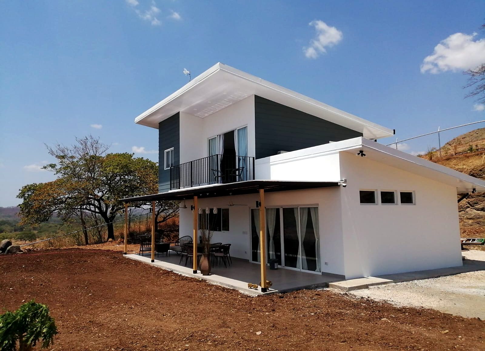 Casa de dos pisos terminada, con terraza techada y balcón
